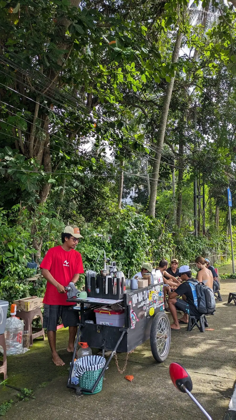 Juandi serving coffee from the NIR-MA-TA cart on the roadside in Senggigi