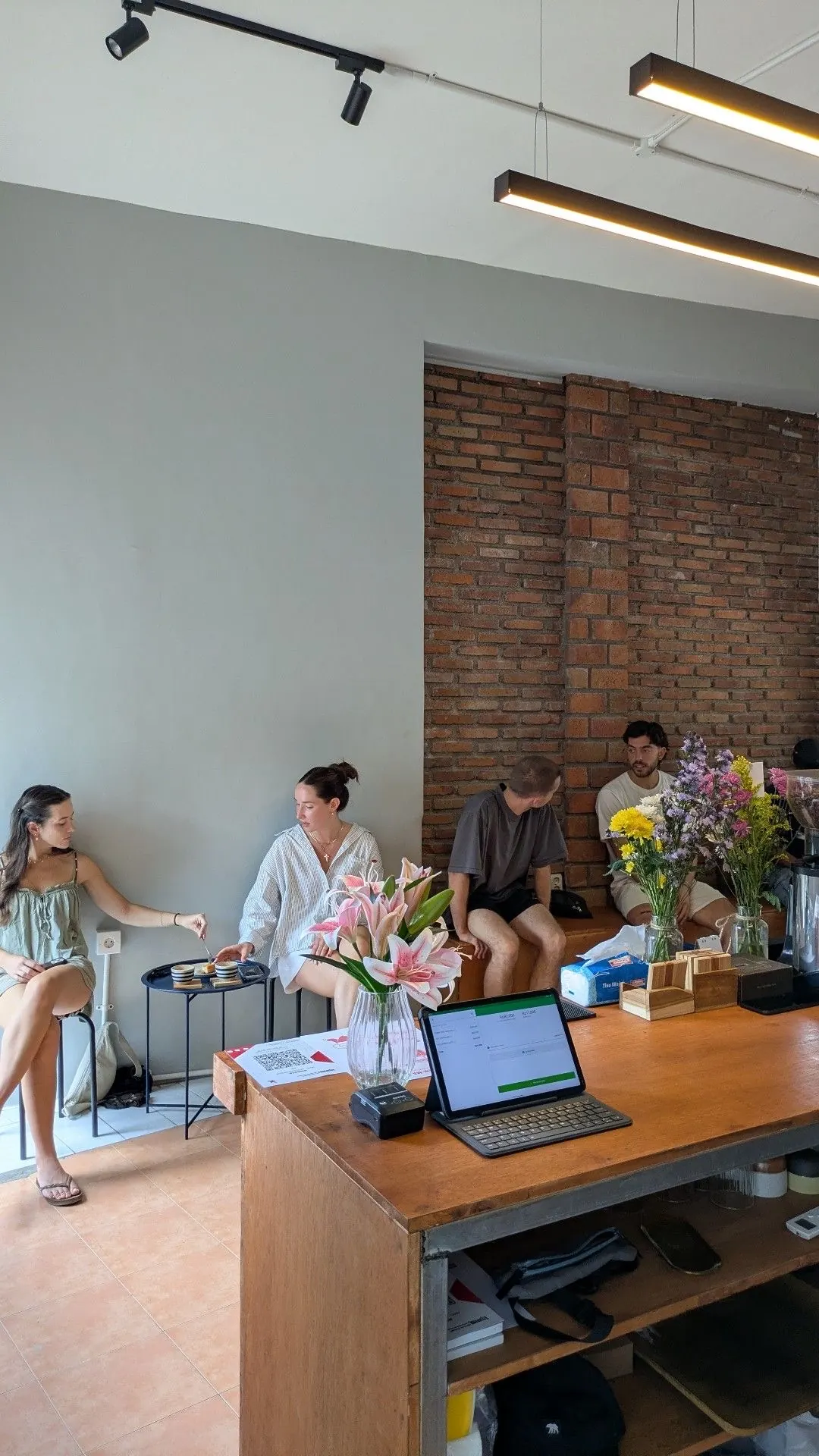 Inside the new NIR-MA-TA shop, brick wall and fresh flowers